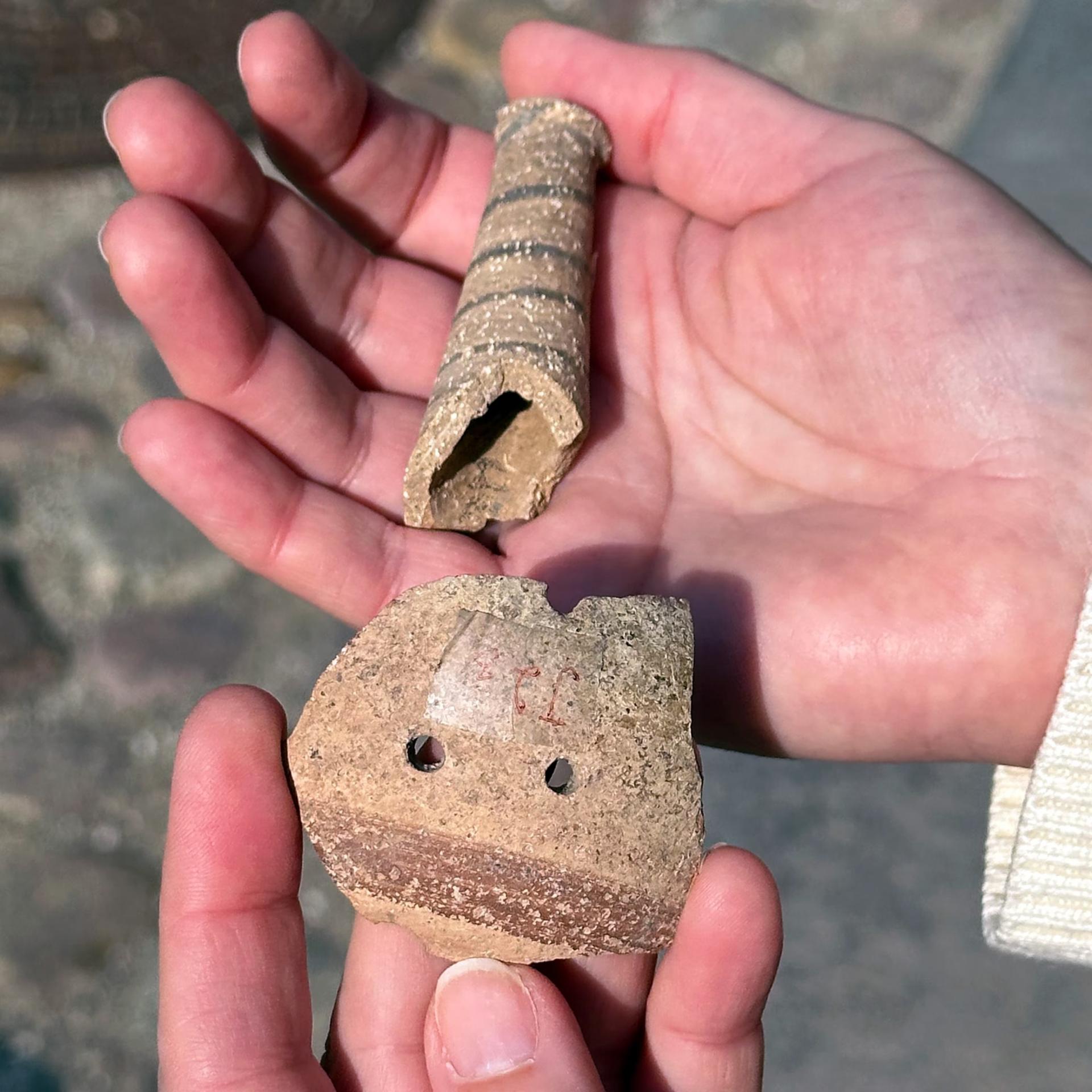 L'archeologa Mette Marie Hald tiene in mano frammenti di sonagli di 4.500 anni fa trovati nel sito di Hama, in Siria. Hald e i suoi colleghi sospettano che i sonagli e altri strumenti simili fossero usati per calmare i bambini piuttosto che per fare musica, come alcuni avevano suggerito in precedenza.